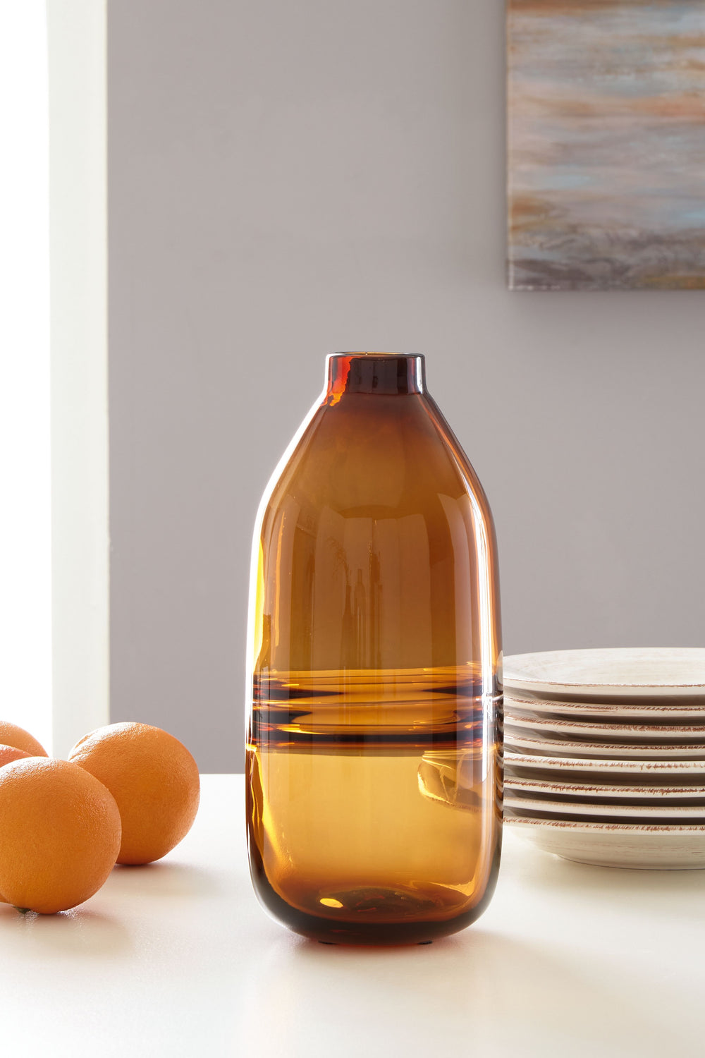 Polish off your patio dining table or office bookshelf with the unassuming-yet-impactful styling of this vase. Its amber finish provides an opaque pop of color to your contemporary decor. Subtle in design, use this vase to punctuate the end of a mantel. O