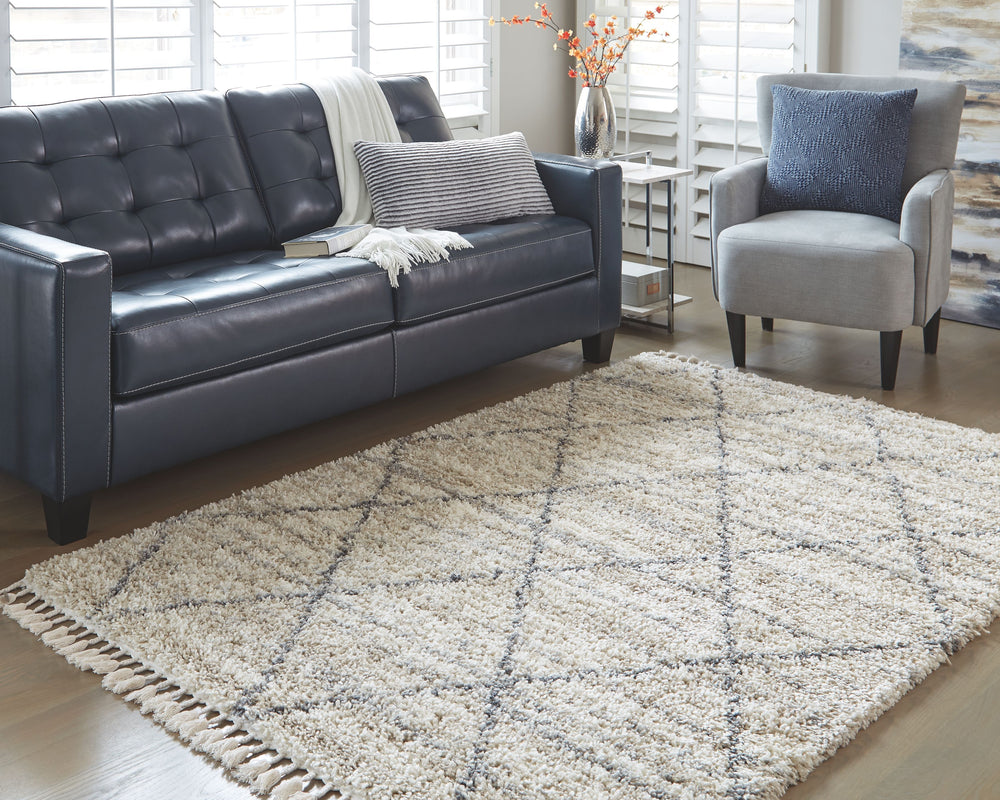 Shake up your style with woven shag. This area rug offers a deliciously comfortable underfoot experience. With a diamond design and braided tassel edge, this floor covering carries a variegated gate pattern in beige, white and shades of gray to elevate yo