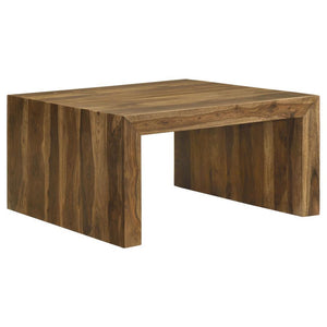 This square coffee table adds an earthy, organic vibe to any living space with its rustic charm. Crafted from sustainable solid sheesham wood, the table boasts an auburn finish that enhances its unique grain patterns. The U-shaped modern silhouette with m