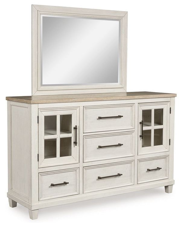 This dresser and mirror set elevates the art of modern farmhouse design. Its two-tone aesthetic blends antiqued white and light grayish brown for a charming finish. Framed drawer fronts and windowpane cabinets lend a country feel. Conveying a feeling of r