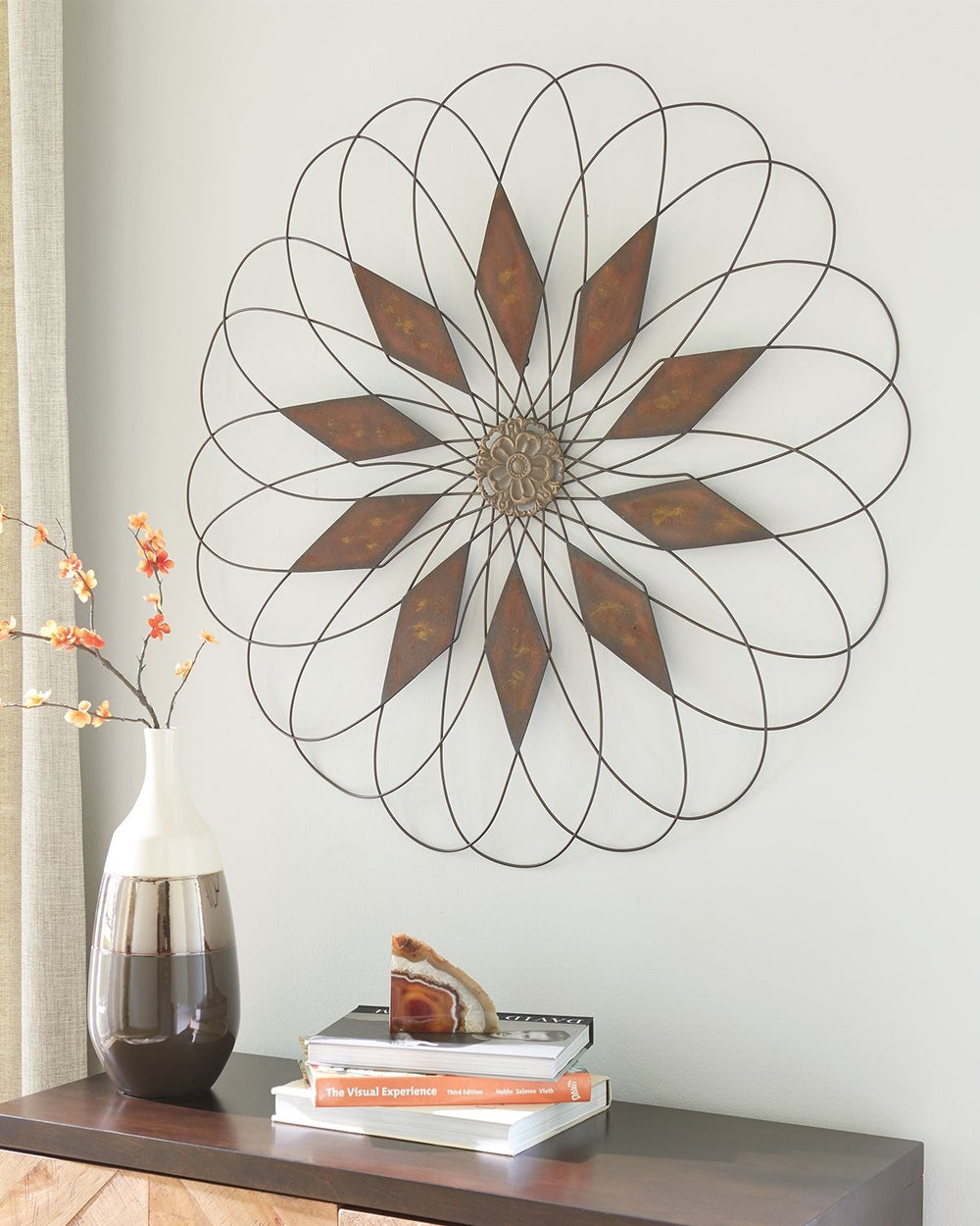 Add a twist of casually cool eleganceâ€”inside or outâ€”with this wall sculpture. Crafted with aged-tone metal thatâ€™s indoor and outdoor safe, it-'ll bring an artful touch wherever you see fit.<br/><br/><b>Product Features</b><ul><li>Made of metal</li><