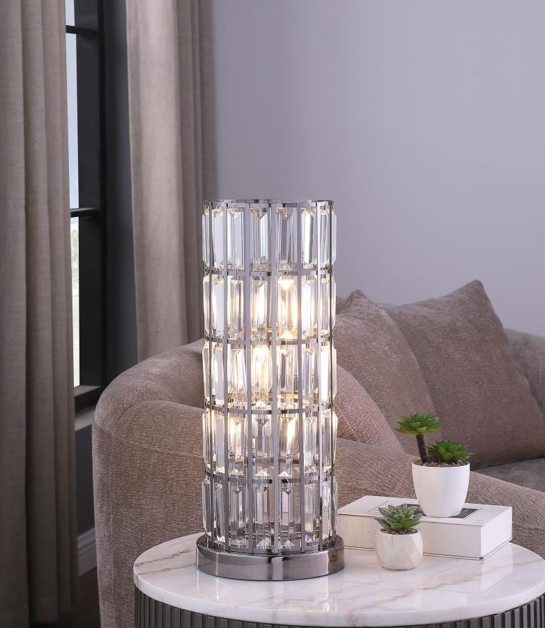 A sleek silhouette brings elegance and regality to a modern three-light table lamp. Adorned with a curtain of sparkling rectangular crystals, it offers glam elegance on a console or side table. Tucked within its column silhouette are three energy efficien