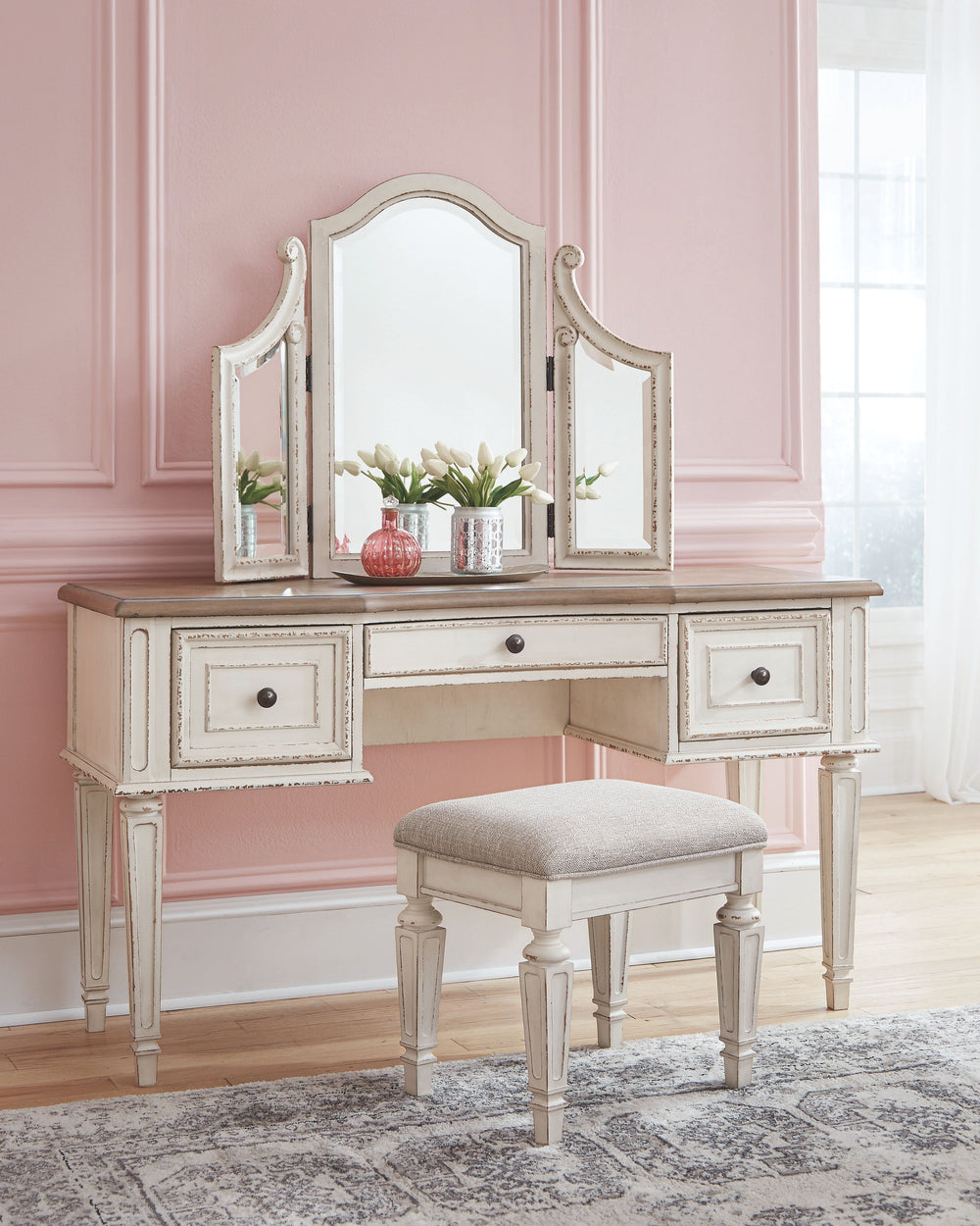Elevating the art of traditional cottage styling, this 3-piece vanity set is your dream bedroom retreat realized. Its antiqued two-tone aesthetic blends a chipped white with a distressed wood finished top for added charm. Framed drawer fronts and a plushl
