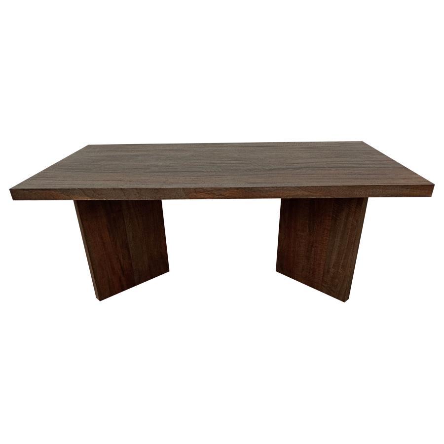 As daylight filters through the windows, it dances upon the surface of a coffee table that exudes a primal elegance. Made from solid mango wood, this rectangular table combines natural charm with timeless durability. Its rich brown finish enhances the woo