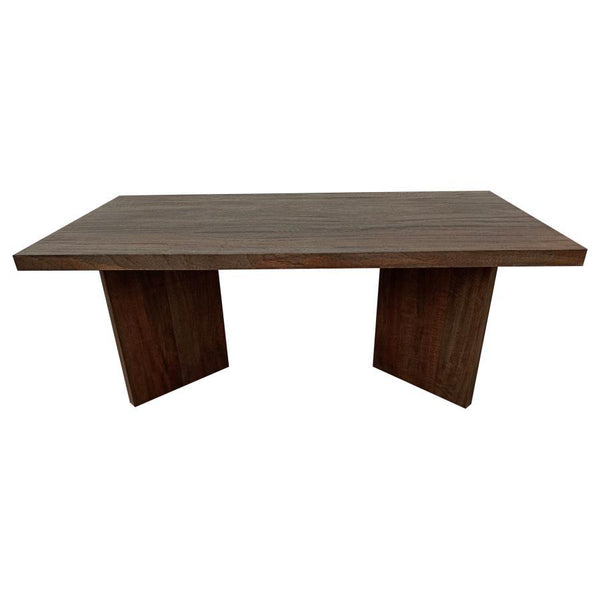 As daylight filters through the windows, it dances upon the surface of a coffee table that exudes a primal elegance. Made from solid mango wood, this rectangular table combines natural charm with timeless durability. Its rich brown finish enhances the woo