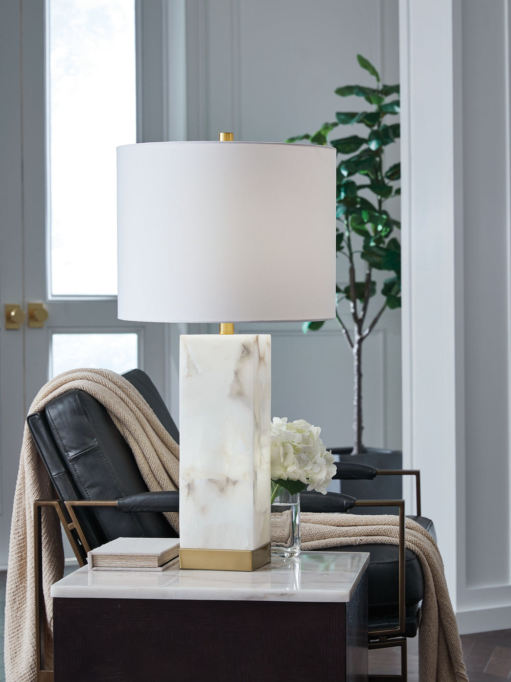 The grandeur and timeless beauty of this contemporary table lamp make it an instant focal point. Made of alabaster with rich goldtone metal accents, the piece makes a style statement whether it-'s sitting pretty atop an end table or flanking the sofa.<br>