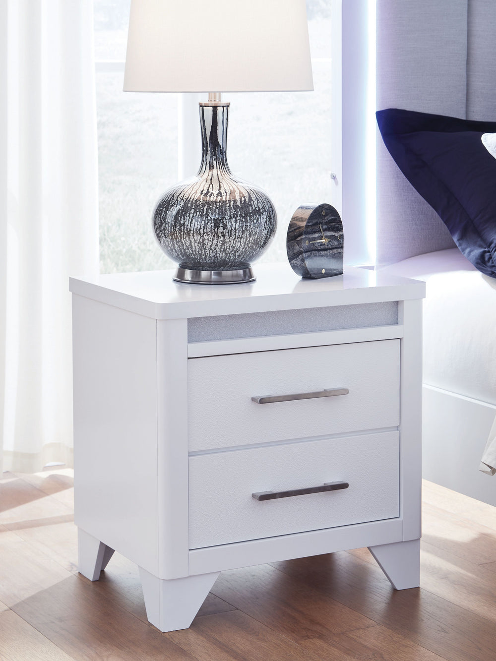 This nightstand is a showstopper, bringing a touch of modern glamour to your sanctuary. A sleek white finish and inset glitter accents create a sophisticated feel, while spacious drawers provide practical storage. Itâ€™s a simply stunning way to achieve t