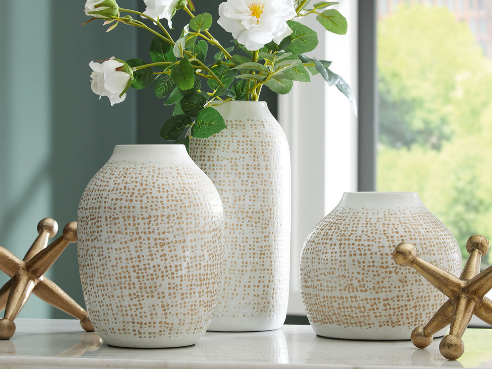 Elevate your decor with this striking accessory set. Its sleek white vases, adorned with delicate goldtone accents, are perfect for displaying your favorite faux blooms or standing alone as minimalist statements. They-'re paired with bold geometric sculpt