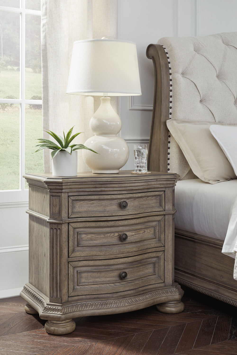 Merging traditional elegance with contemporary comfort, this nightstand takes your bedroom retreat to the next level. Serpentine curves, ash swirl veneer inlays on the top and a glazed antiqued-look finish radiate timeless sophistication. Drawers are pack