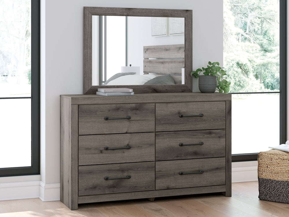 Combining a casual aesthetic with functional flair, this dresser with mirror suits styles from rustic to industrial. Its smooth-gliding drawers store everyday essentials with ease, from clothes to bed linens. Elongated drawer pulls in a dark hue polish of