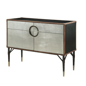 With its riveted patchwork of polished aluminum, the Brancaster console table is inspired by mid-20th-century air travel. This unique console piece features ample storage with two drawers and cabinet space with two doors, all supported by tapered metal le