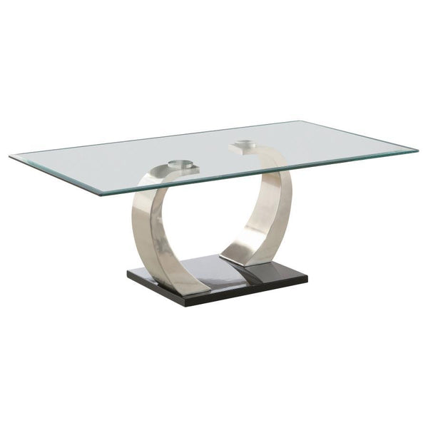 Elevate your living space with this modern coffee table, showcasing a tempered glass top for enhanced durability and style. The dual curved bases feature a brushed satin silver finish, adding sleek contemporary appeal, while the polished black platform ba