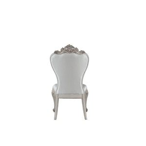  decorated with raised and scrolled floral motifs in an antique champagne finish. This unique chair is upholstered in a cream fab