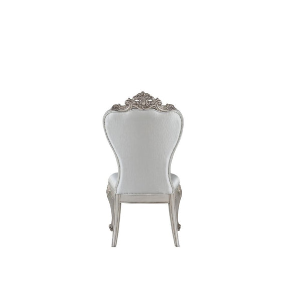  decorated with raised and scrolled floral motifs in an antique champagne finish. This unique chair is upholstered in a cream fab