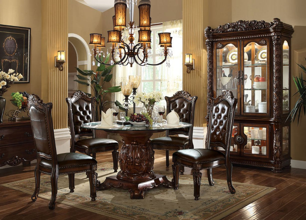 The Vendome traditional dining collection features a pedestal dining table complemented with oversized upholstered chairs all accented by floral carving decorative base and feet. Matching curio reflects all carefully selected design features as the dining