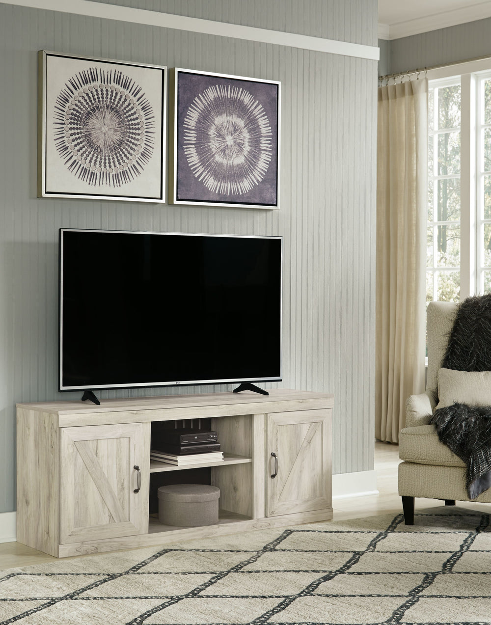 Express your modern farmhouse style with this TV stand with fireplace option. Its wispy white finish over replicated oak grain is a delightful change from the ordinary. Clean-lined, classic styling with barn door inspiration provides a country-chic aesthe