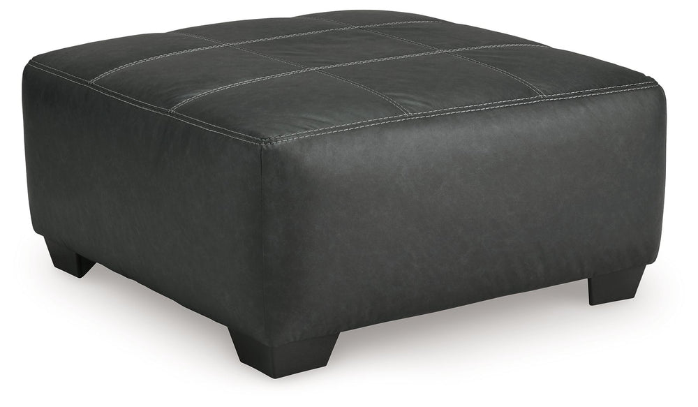 Appeal to your eye for ultra-contemporary design with this oversized accent ottoman. Chic and sleek in dark neutrals, it pairs cozy fabric with faux leather for invitingly cool character. And with its robust size offering extra legroom, you can chill out 
