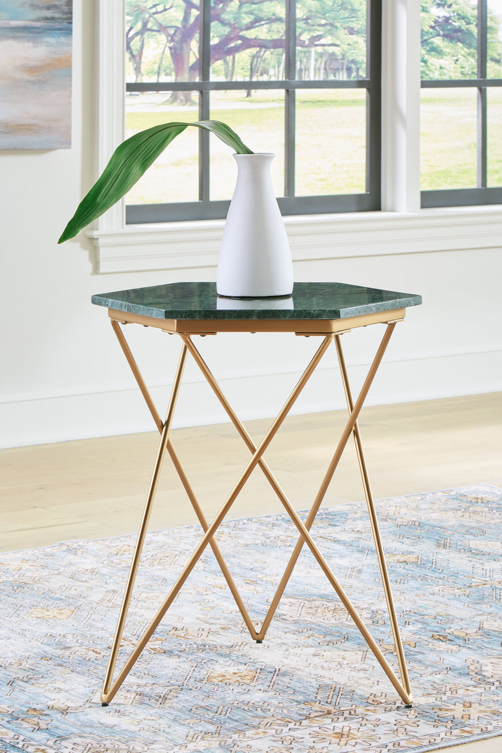 This accent table redefines classic glamour for the modern age. It draws from art deco influences with its geometric goldtone base, while the green marble top will be the envy of every guest. Thereâ€™s no place quite like home, and this table crafts a con