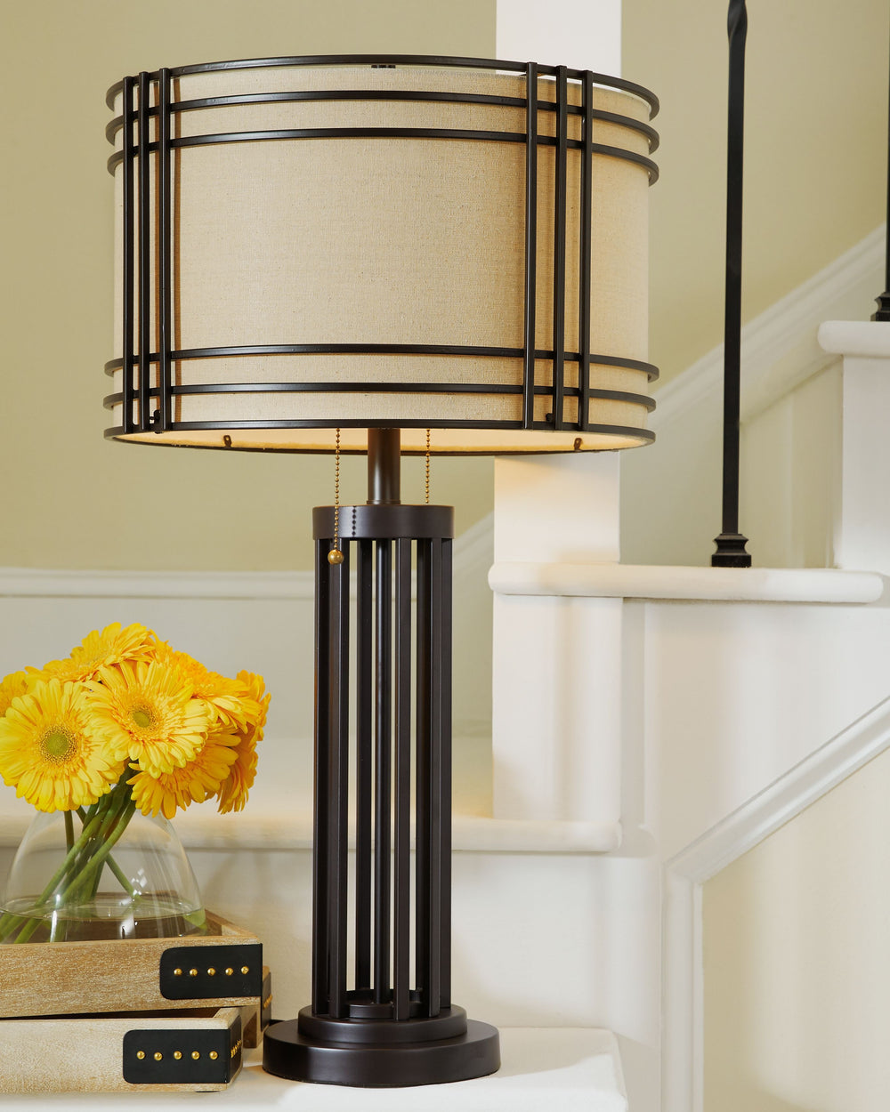 Add a touch of rustic industrial style to your decor with this eye-catching table lamp. Its drum shade and decorative metal frame bring an appealing touch to your home. A dark brown finish complements the shade-'s lighter neutral color, making this lamp i