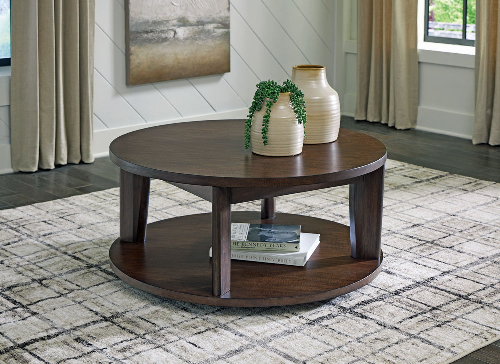 It-'s hard to say what-'s most striking about this round coffee table. Is it the rich warm brown finish or the thick tapered legs? Either way, the table-'s clean, contemporary aesthetic is perfect for your casual lifestyle. Casters let you roll the coffee
