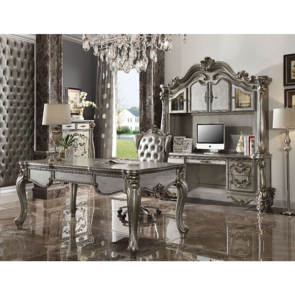 The Versailles executive arm chair classic style will blend masterfully in your home. Carefully constructed from faux leather, and selected veneers in rich antique platinum finish. Highly decorative details, button tufted backrest with Nailhead trim, and 