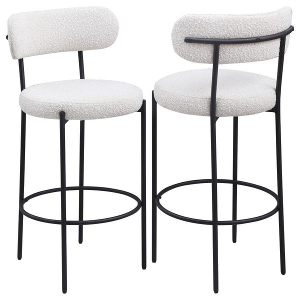 Refresh your kitchen island or elevated bar table with a set of two modern barstools. Each features foam cushions and contemporary boucle upholstery in a neutral hue. Black finish metal framing provides excellent support and durability, while slim legs an