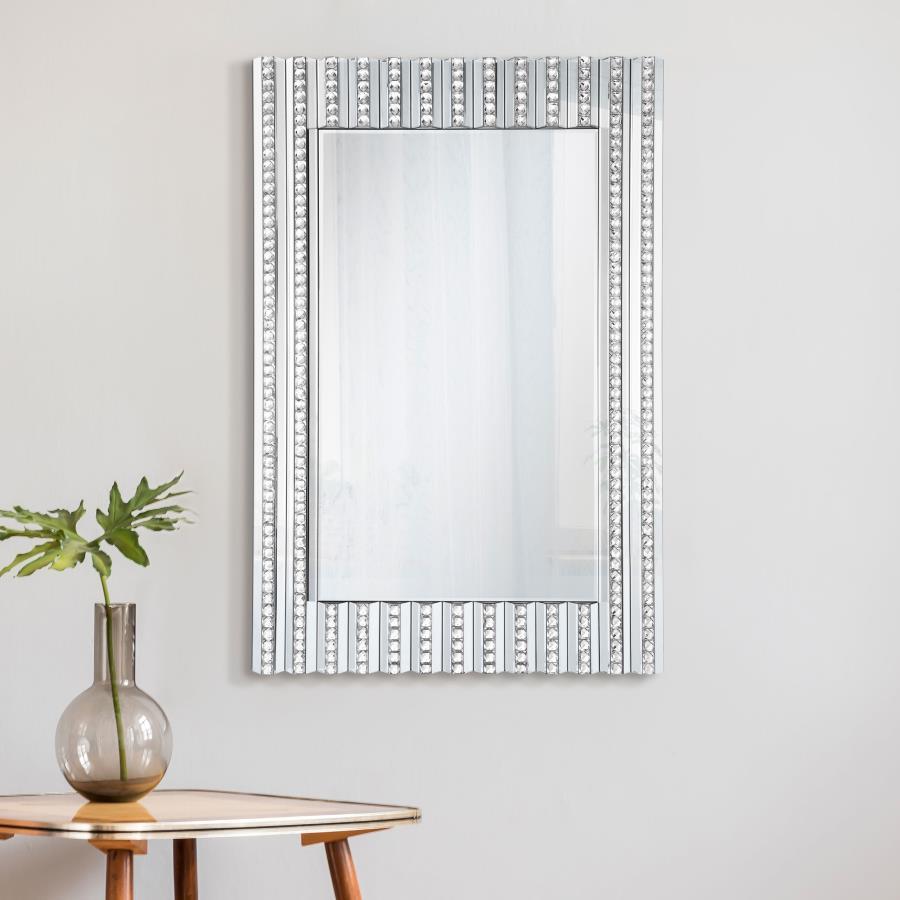 Mount this stunning glam mirror on an entryway foyer wall or above a bathroom vanity for a bit of sparkle. With a long rectangular shape and dimensional frame, this contemporary style mirror is sure to catch the eye. Vertical lines fuse together, half of 
