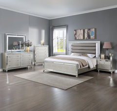 Elevate your sanctuary with this dazzling bedroom collection, where contemporary chic meets timeless charm. The suite boasts a stunning silver finish, imbuing your space with an air of sophistication and modern luxury. At the heart lies a plush, channel t