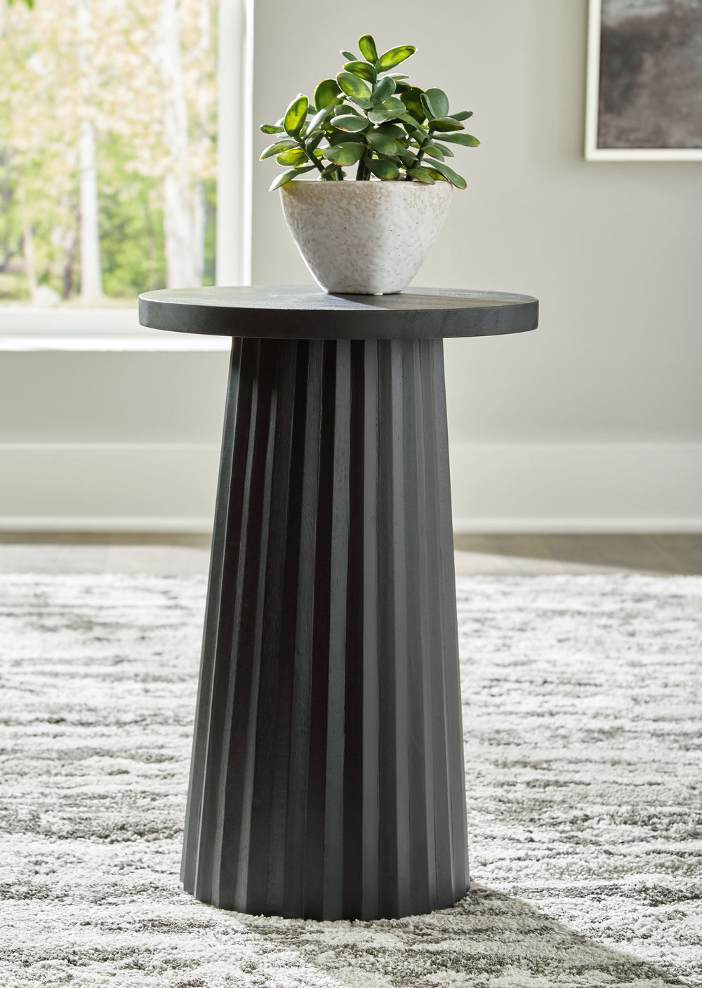 Show off your trend-right sensibilities with this contemporary accent table. Designed for the modern tastemaker, the solid wood piece wows with a fluted base. This organic beauty can be used on its own or grouped with other pieces in the collection. Howâ€