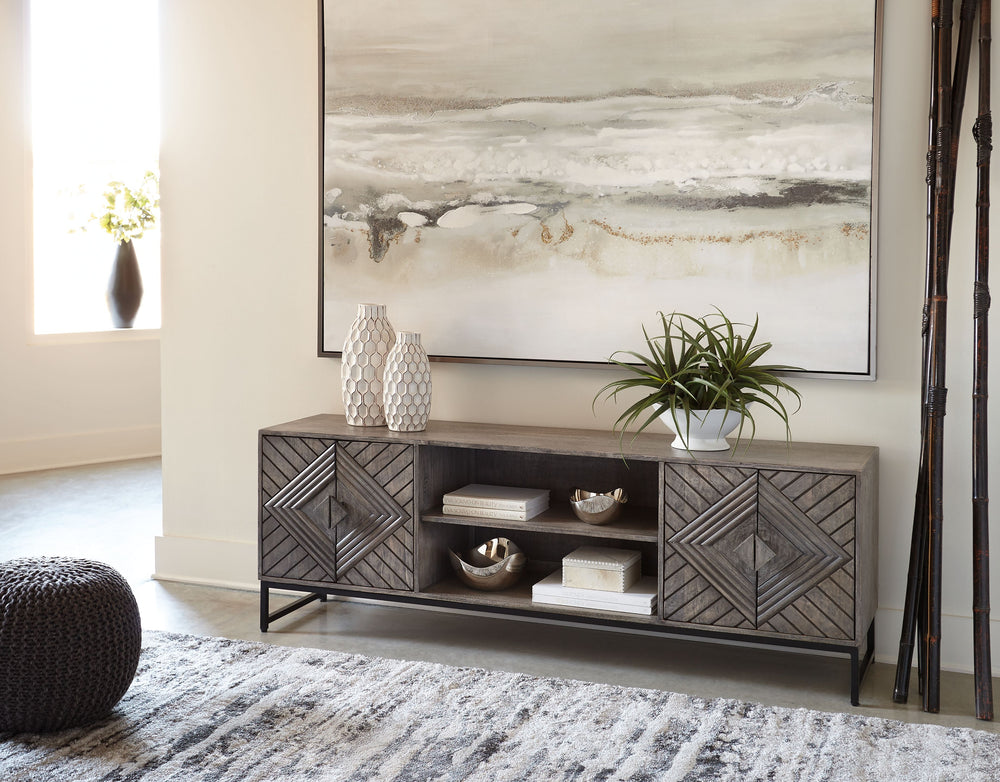 For admirers of understated vintage glamour, this accent cabinet beautifully complements your desired aesthetic. The classic charm of a distressed gray finish meets chic metropolitan styling, with art deco-inspired door fronts and an industrial black meta