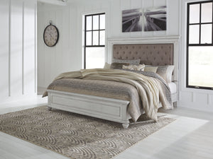 Give your retreat vintage charm with this California king upholstered panel bed. In a beautifully distressed whitewash finish, you-'ll love the headboard-'s grand style featuring an inset button tufted upholstery cushion. Generously scaled moulding from t