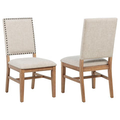 This refined dining side chair enhances any mealtime experience with subtle elegance. Upholstered in beige fabric, it features individually hand-driven black nailhead trim for artisanal detail. Crafted with a solid hardwood frame and legs in a natural bro