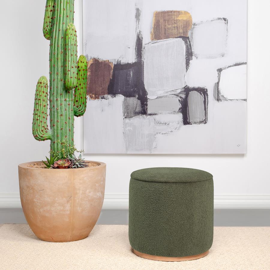 Add a touch of playful luxury to your living space with this round upholstered ottoman, swathed in sumptuous faux sheepskin that invites you to touch. Resting on a metal base that-'s been expertly finished to emulate the warm, natural allure of wood grain