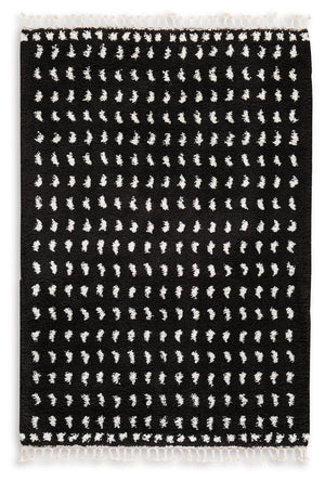 Sink your feet into this modern area rug. Offering a luxurious shag with woven dot design in black and white, this rug adds sophistication to any space without sacrificing comfort or durability. Finished with a braided tassel edge completing the design, t