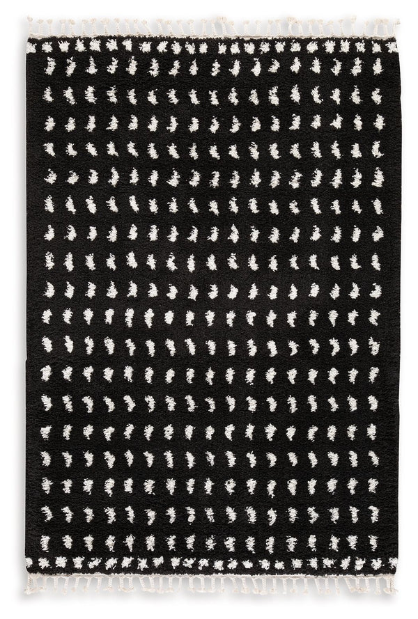 Sink your feet into this modern area rug. Offering a luxurious shag with woven dot design in black and white, this rug adds sophistication to any space without sacrificing comfort or durability. Finished with a braided tassel edge completing the design, t