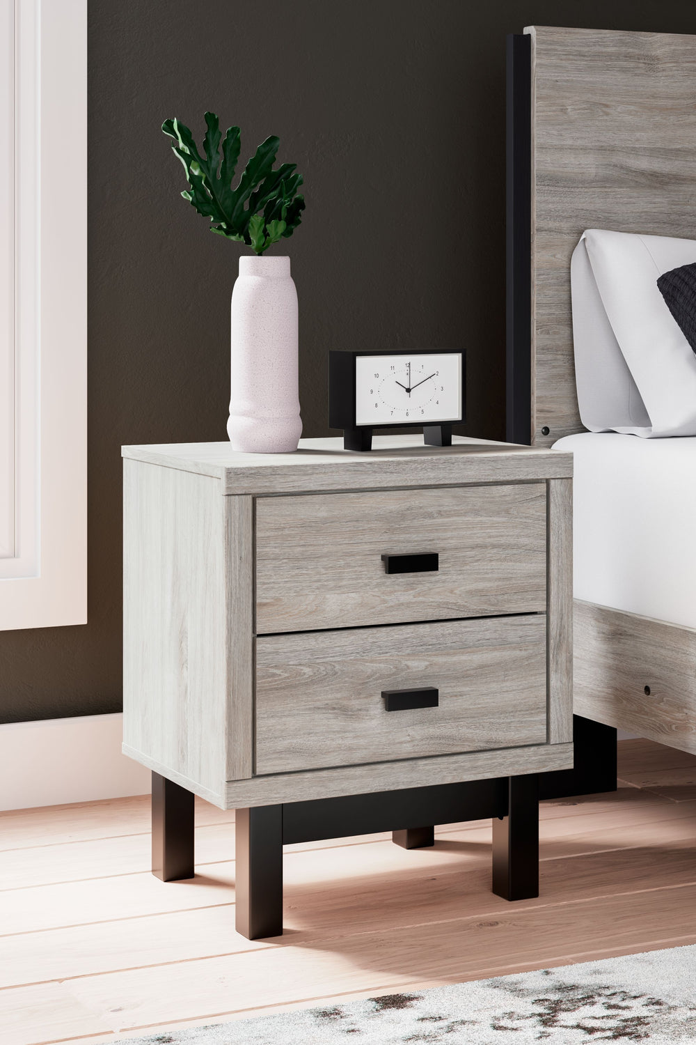 Craft a contemporary hideaway without breaking the bank. An elegant juxtaposition of refined neutral hues, this two-toned nightstand brings sleek style to your space. Matte black drawer handles enhance the sheer simplicity of its profile. With this bedsid