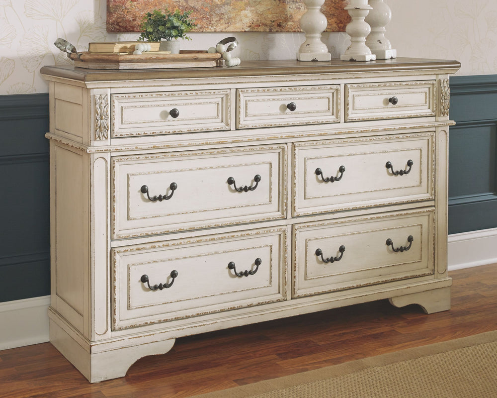 Elevating the art of traditional cottage styling, this dresser is your dream bedroom retreat realized. Its antiqued two-tone aesthetic blends a chipped white with a distressed wood finished top for added charm. Framed drawer fronts and decorative corbels 