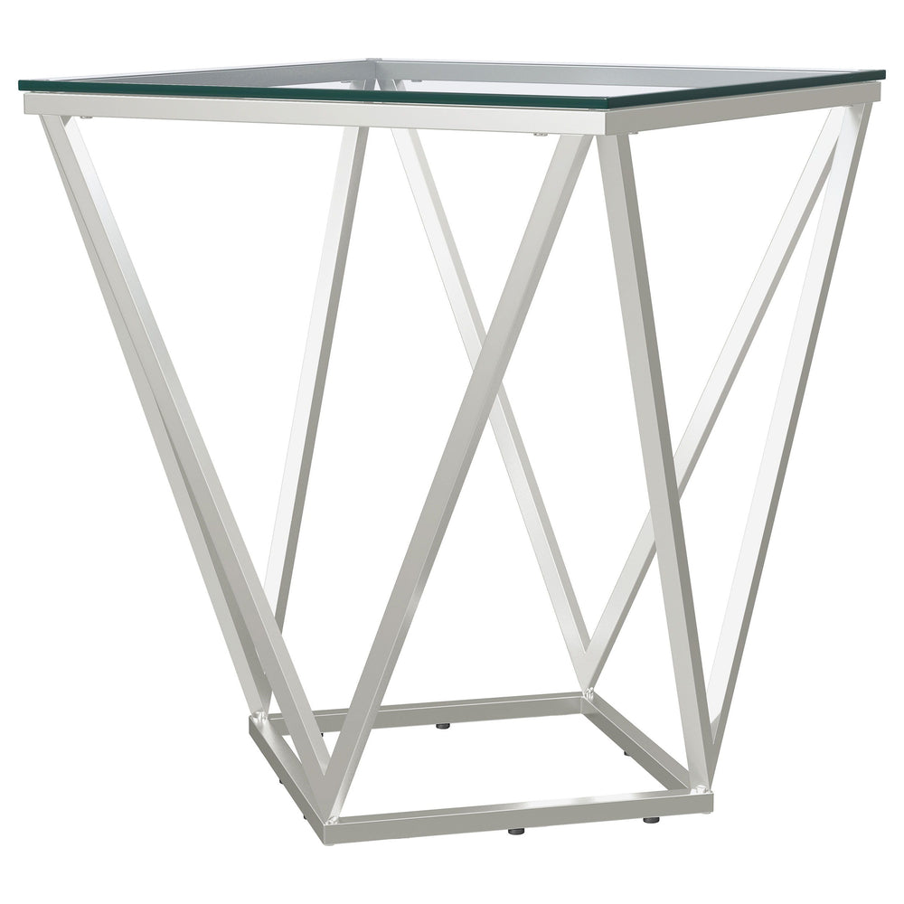 Simple geometric shapes combine to form a strikingly modern end table. The design features open, flared triangles in metal with a gleaming nickel finish, creating a dynamic base. A square glass top offers a smooth, airy surface, perfect for displaying dec