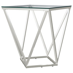 Simple geometric shapes combine to form a strikingly modern end table. The design features open, flared triangles in metal with a gleaming nickel finish, creating a dynamic base. A square glass top offers a smooth, airy surface, perfect for displaying dec