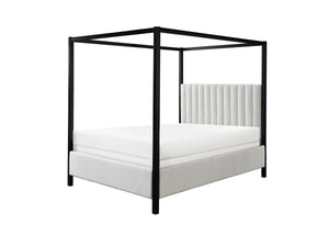 This canopy bed is a modern statement piece, blending the luxurious feel of a traditional four-poster bed with the clean, sleek lines of contemporary design. Its bold, black frame creates a striking silhouette against any bedroom backdrop, while the plush
