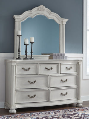  highlighted by a serpentine-shaped front with thick decorative moulding. Its dra