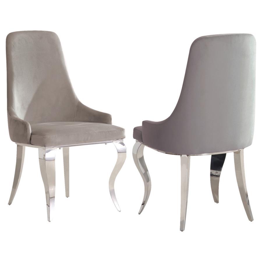 Immerse yourself in the epitome of elegance and comfort with this upholstered dining chair. Draped in soft velvet, the tailored wingback and demi-arm silhouette offer a plush slipper-style seat ideal for formal dinners and long conversations. Cabriole-sha