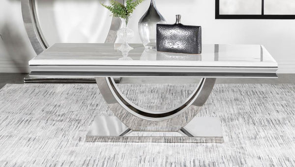  featuring a marble-like appearance and beveled edges. Its sweeping demilune pedestal base