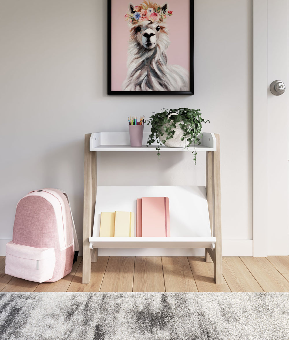 Whether for storage or display, this stylish small bookcase provides the perfect place to prop their ever-expanding book collection. The unique angled lower shelf and gallery rail top in white charmingly contrast with the light tan frame, creating a versa