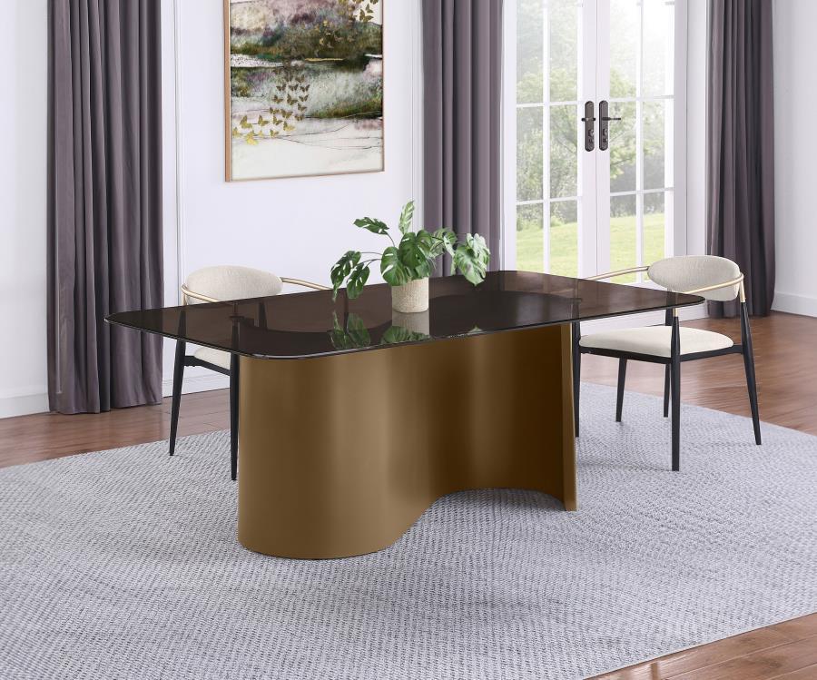 This bold dining table brings modern sophistication to your dining space with its striking design and luxurious finishes. The semi-opaque tempered glass top, finished in a rich tawny hue with rounded corners, beautifully contrasts the flowing, sculptural 