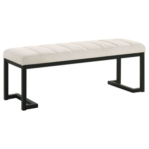 Textured upholstery play perfectly with the modern silhouette of a backless accent bench. Its deep black finished frame is constructed in metal for excellent durability, with a bracket inspired silhouette that emphasizes its contemporary design credential