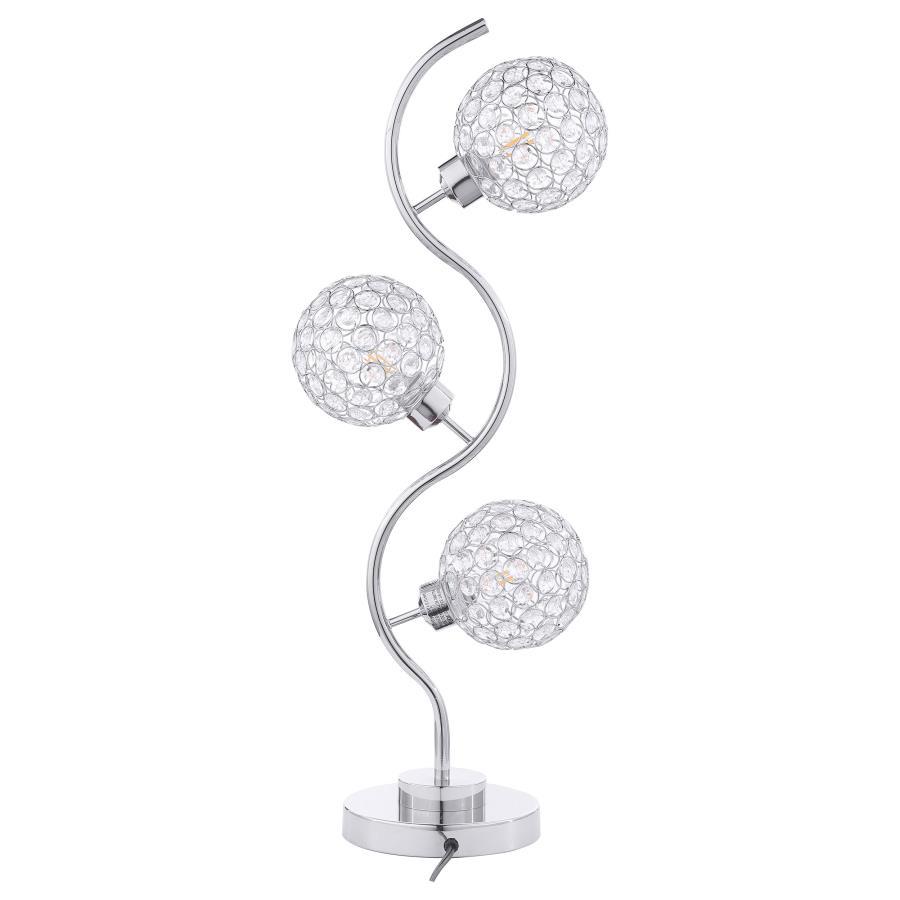 Sparkling with glamour, this modern three-light table lamp is a superb choice for a sophisticated living space. A corkscrew inspired post gleams in a chrome finish and hosts its three lights. Each features an orb shade dotted with crystal-like embellishme