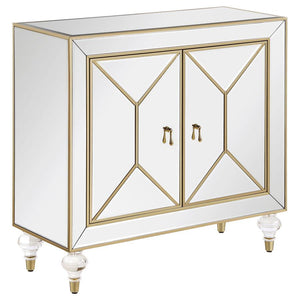 This glamorous accent cabinet lends an air of sophistication and elegance with its polished mirror surfaces and champagne accents. With an inverted beveled design along each of the dual cabinet doors, outlined by a champagne trim, this contemporary accent
