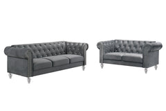 The New Classic Emma Chesterfield Velvet 2-Piece Sofa and Loveseat Set offers a soft and elegant seating solution for your living space. The 100% polyester velvet fabric provides cozy and indulgent seating, while the tufted backs and arms, adorned with gl