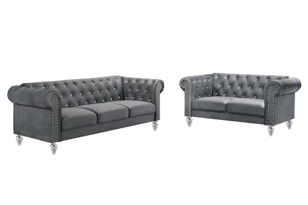 The New Classic Emma Chesterfield Velvet 2-Piece Sofa and Loveseat Set offers a soft and elegant seating solution for your living space. The 100% polyester velvet fabric provides cozy and indulgent seating, while the tufted backs and arms, adorned with gl